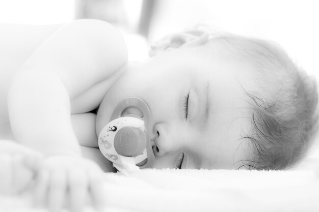 Photo close-up of baby sleeping on bed