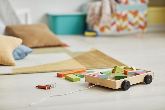 Close up background image of wooden toy set in minimal kids playroom interior copy space