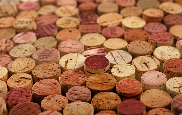 Close up background pattern of many assorted stacked used red wine corks, high angle view