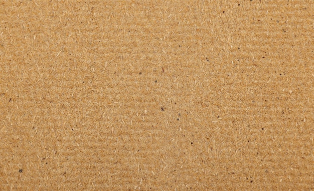 Close up background texture of unpainted natural brown wooden fiberboard plate, sheet construction material also used for furniture production