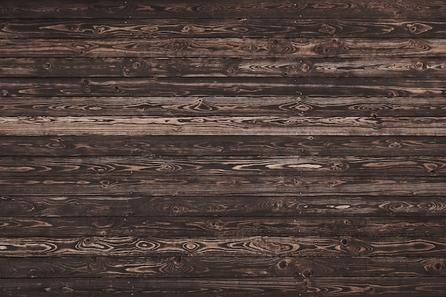 Close up background texture of vintage weathered brown wooden planks with knots and stains