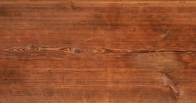 Close up background texture of vintage weathered brown wooden surface with knots and stains