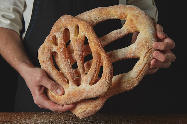 Close up of a baker hands with fougas bread