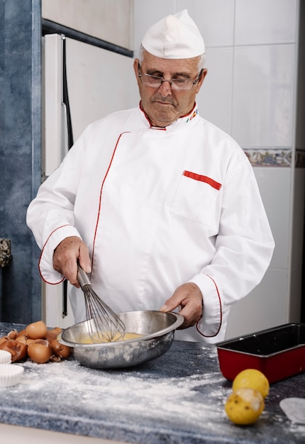 Close-up of a baker mixing eggs with a hand blender