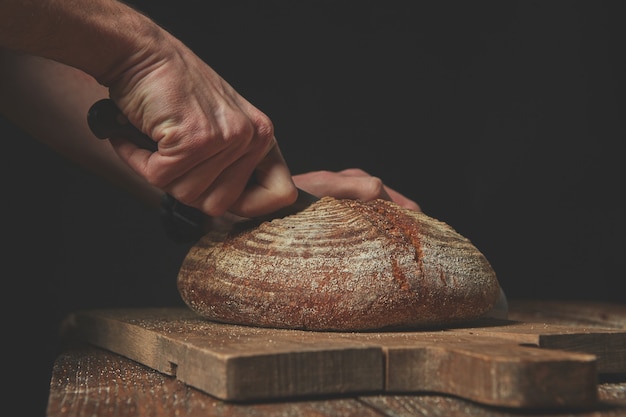 Primo piano del pane tondo fresco affettato a mano di un fornaio