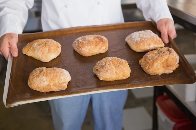 Close up of baker showing tray with bread