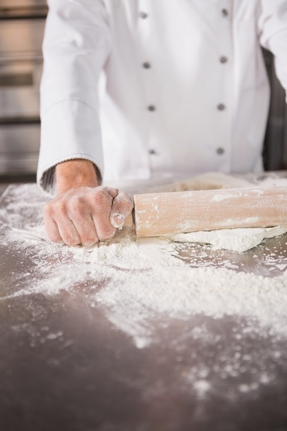 Close up of baker using a rolling pin