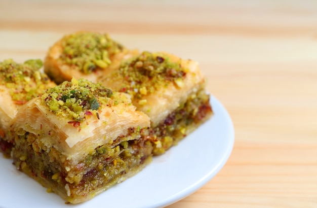 Close-up of Baklava Sweets with Pistachio Nuts Served Wooden Table