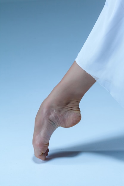 Close-up ballerina's leg on the blue floor