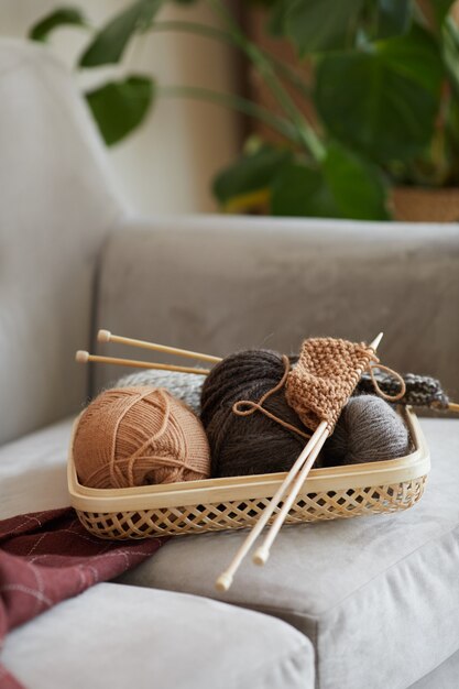 部屋のソファで編むための羊毛のボールのクローズアップ