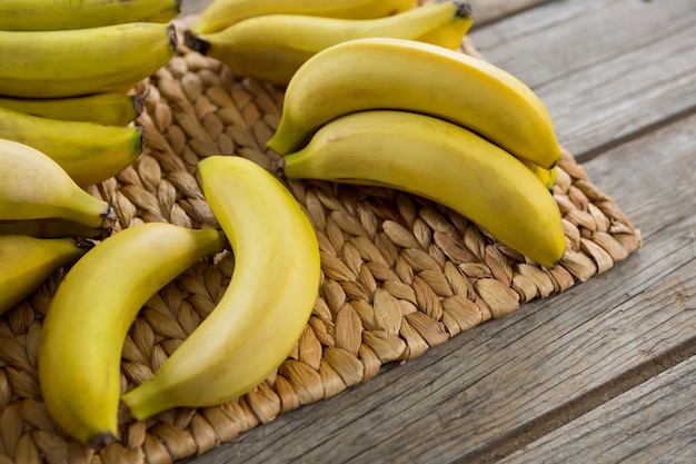 Close-up of bananas kept on placemat on wooden table