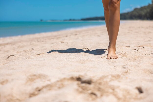 Close up Bare foot woman walking on golden sand beach in Khao Lak Phang Nga Thailand Summer vacation