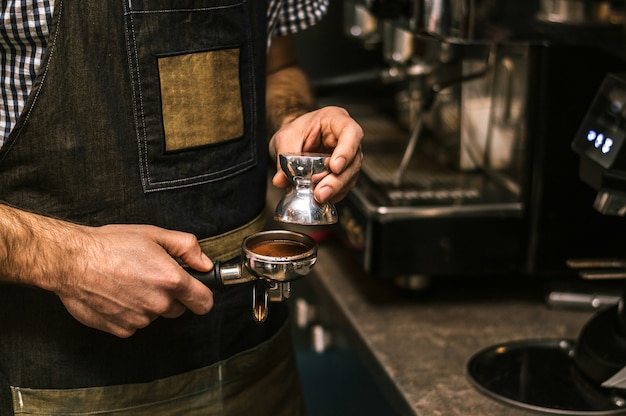 Foto chiuda sul barista che prepara il latte.