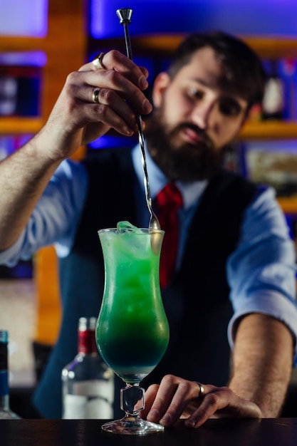 Close up of barman decorate blue lagoon cocktail