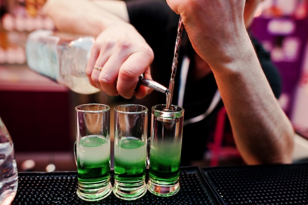 Close up barman hands  preparing green mexican cocktail drink at the bar