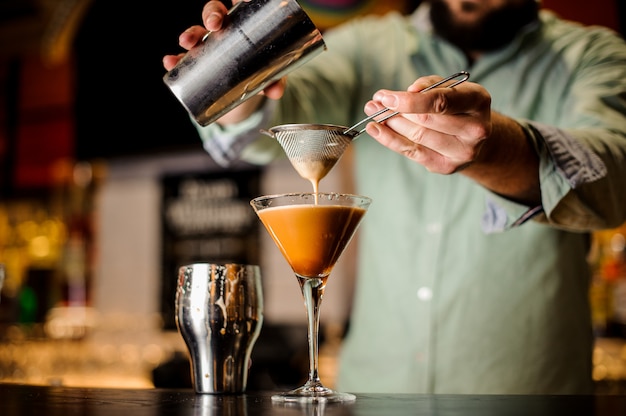 Close up barmans hands with coffee cocktail