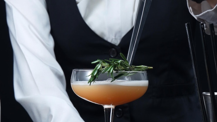 Photo close up of bartender prepare cocktail with orange and rosemary comestible