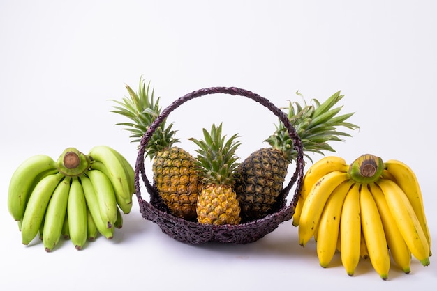 Primo piano del cesto con ananas e banane sul lato