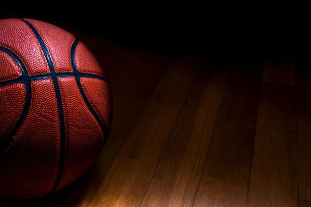 Photo close-up of basketball on hardwood floor