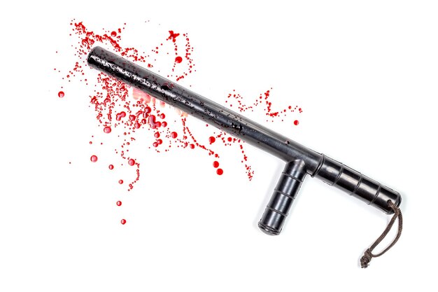 Close-up of baton and blood against white background