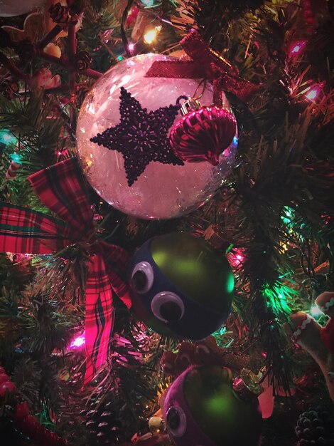 Foto close-up di gioielli e coni di pino decorati sull'albero di natale