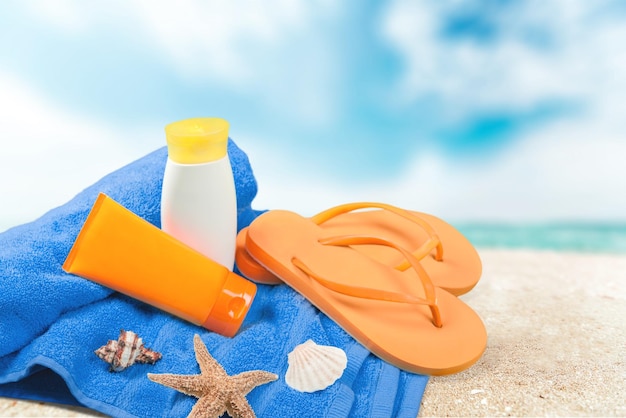 Close-up of beach accessories . Flip-flops, oil, shells,towel