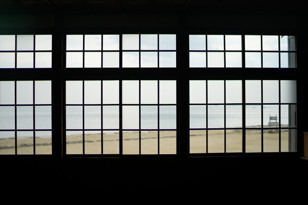 Close-up of beach seen through window against clear sky