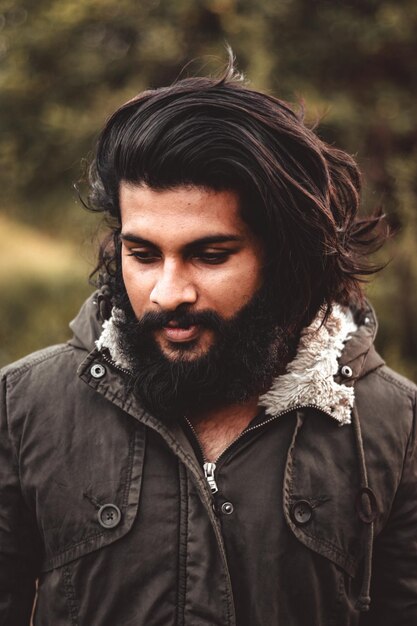 Photo close-up of bearded young man looking away outdoors