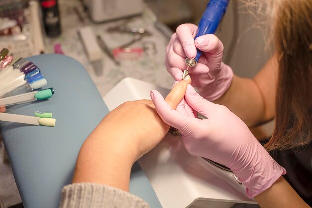 Foto close-up di un estetista che fa la manicure a un cliente al salone