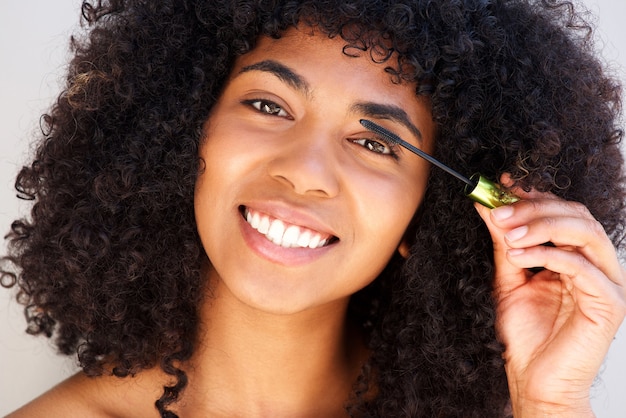 Chiuda sulla bella donna afroamericana che mette sopra componga