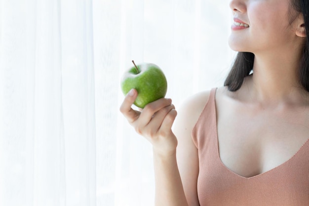 Close up beautiful beauty sexy woman slim holding green apple on white bedroom background