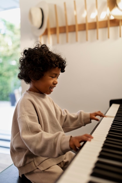 Photo close up on beautiful black toddler playing piano