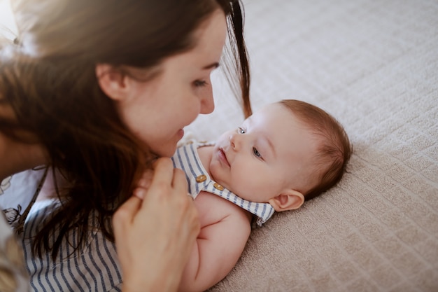 Close up of beautiful Caucasian mom talking to her adorable baby boy.