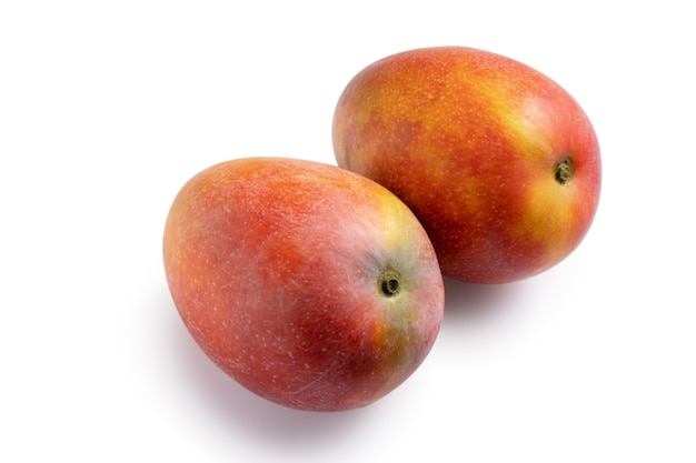 Закройте красивые вкусные спелые манго, изолированные на белом фоне таблицы, вырезать путь.