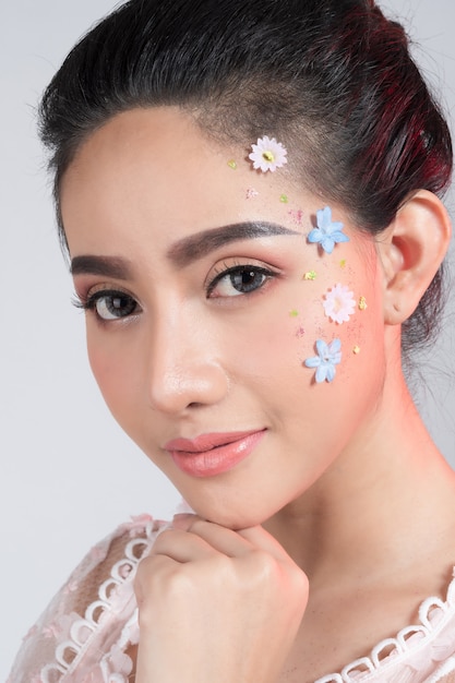 Close Up on beautiful face with colorful flower 