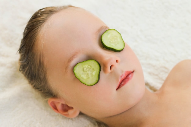 Close up of beautiful girl with facial mask of cucumber 