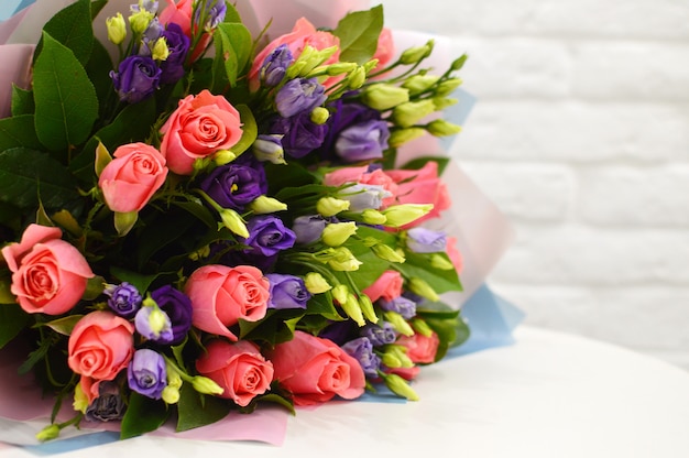 Close-up beautiful lovely bouquet of mixed flowers on white table. Close-up beautiful bouquet of colorful flowers. Flower shop concept