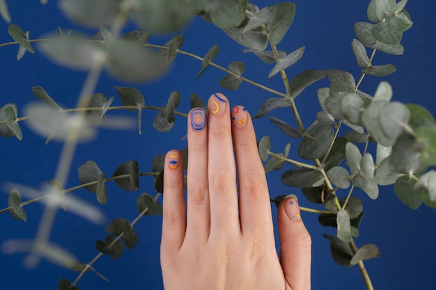 Photo close up beautiful manicure and green leaves