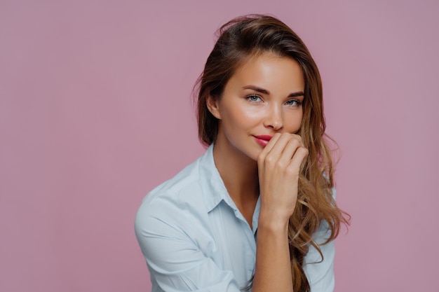 Foto close-up di una bella donna sullo sfondo rosa