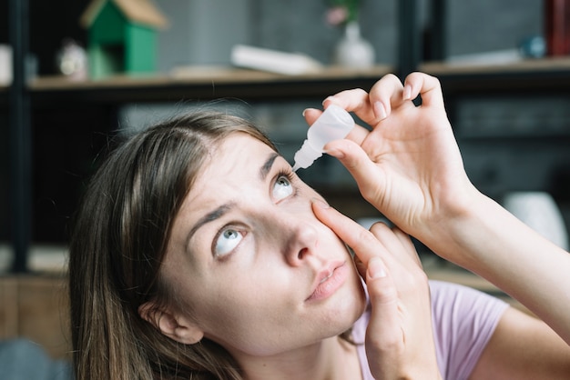 Foto primo piano di una bella donna applicando collirio