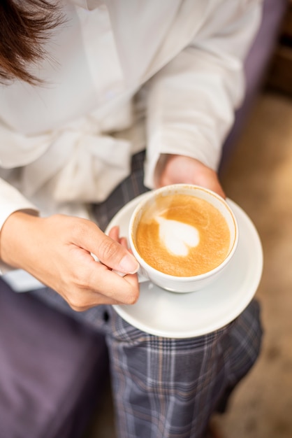 美しい女性のクローズアップはコーヒーを飲んでいます