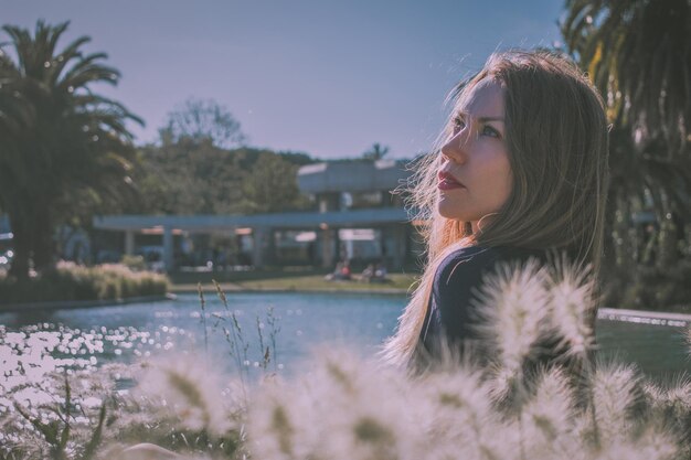 Foto close-up di una bella donna che guarda da un'altra parte mentre è seduta all'aperto