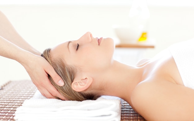 Close-up of a beautiful woman receiving a head massage