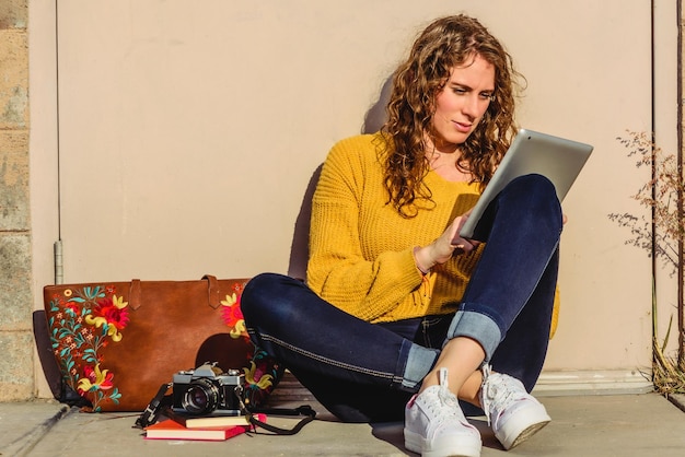 Close up of beautiful woman sitting at the street outdoors, taking notes in a notebook