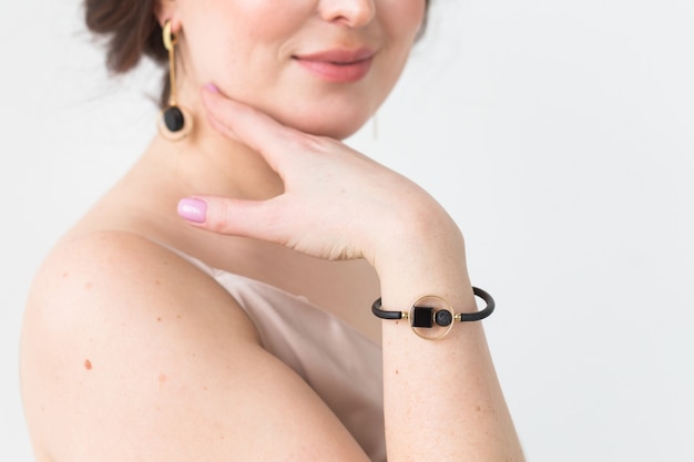 Photo close-up of beautiful woman wearing necklace and the pearl bracelet. accessories, jewelry and bijouterie.