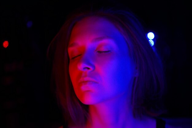 Close-up of beautiful woman with light in nightclub