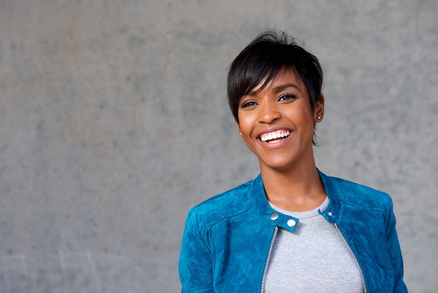 Close up beautiful young black woman with blue jacket smiling 