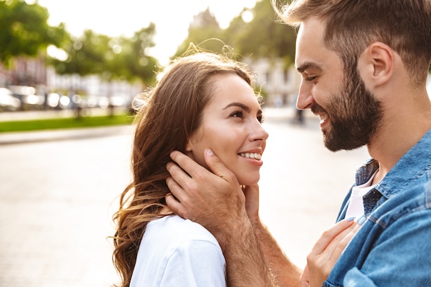 Close up of a beautiful young couple in love walking outdoors at the city street, embracing