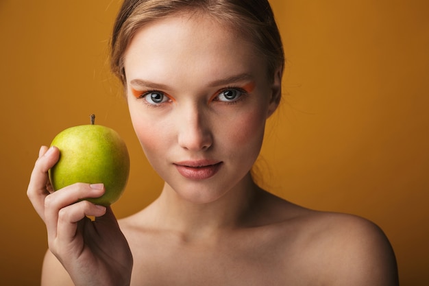 Close up beauty portrait of a beautiful sensual young woman isolated, holding green apple