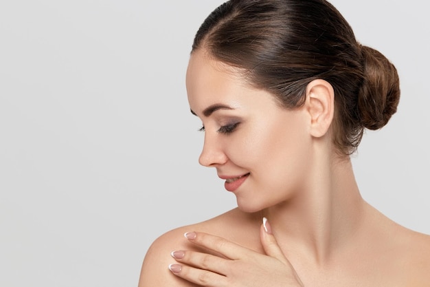 Close up beauty portrait of a laughing beautiful half naked woman applying face cream